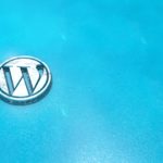 Wordpress symbol close up - metal shape on blue, ice background. Render 3D.